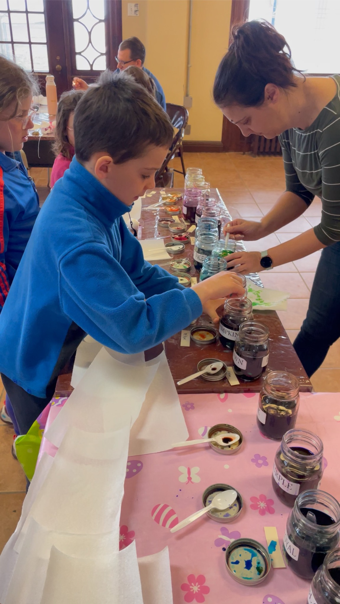 Enfant trempant un œuf dans la teinture